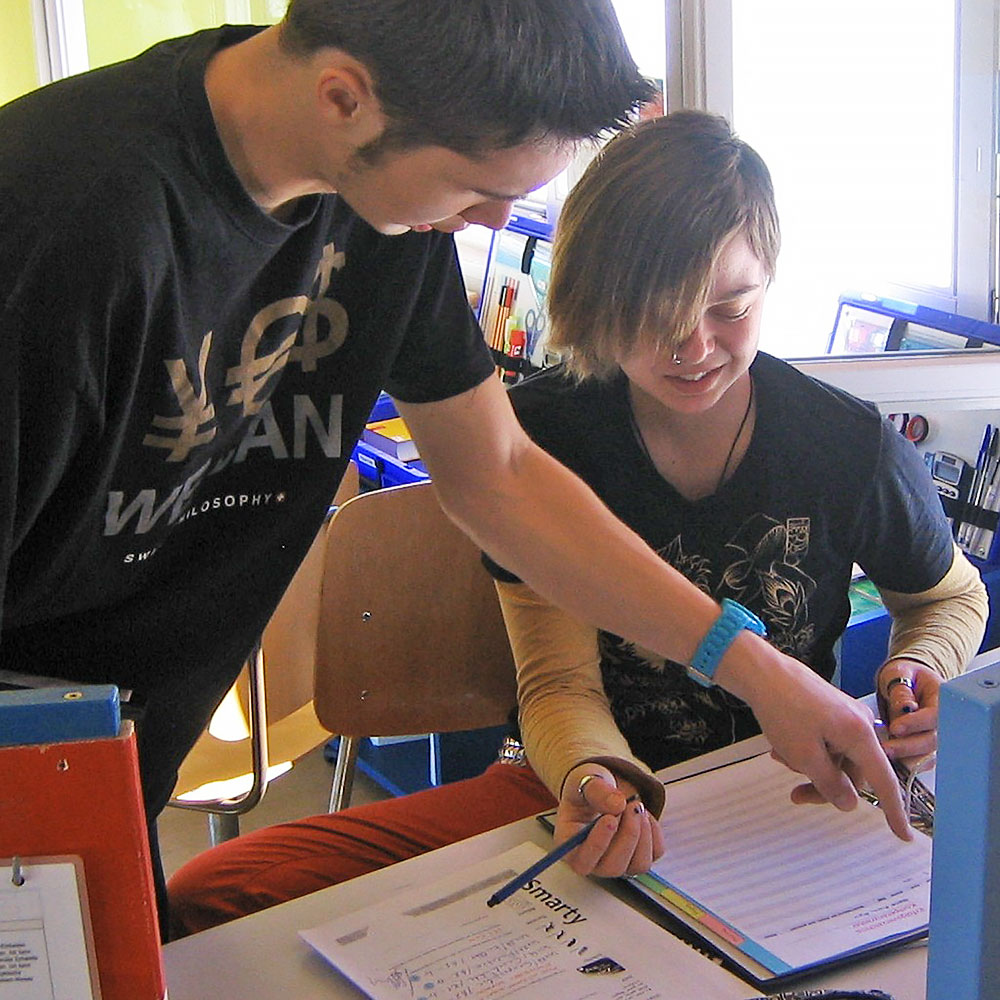 eine Schülerin füllt zusammen mit einem Mitschüler ein Arbeitsblatt aus